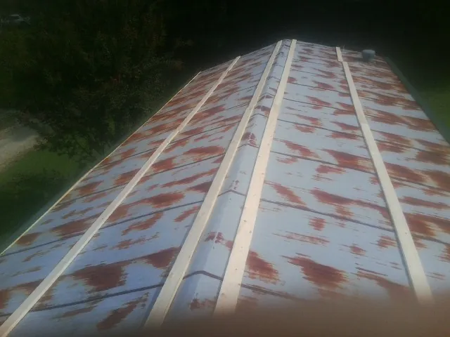 Rusted metal roof panels with new wood purlins before replacement — Storm Damage Roof Repair in Magee by Roofing Brothers