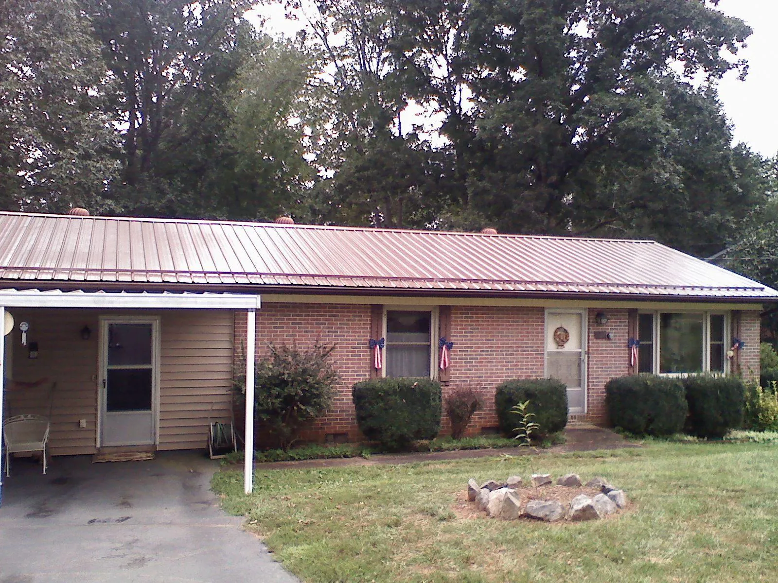 Bronze metal roof and carport on a brick ranch home — Roof Repair work by our crew in Magee