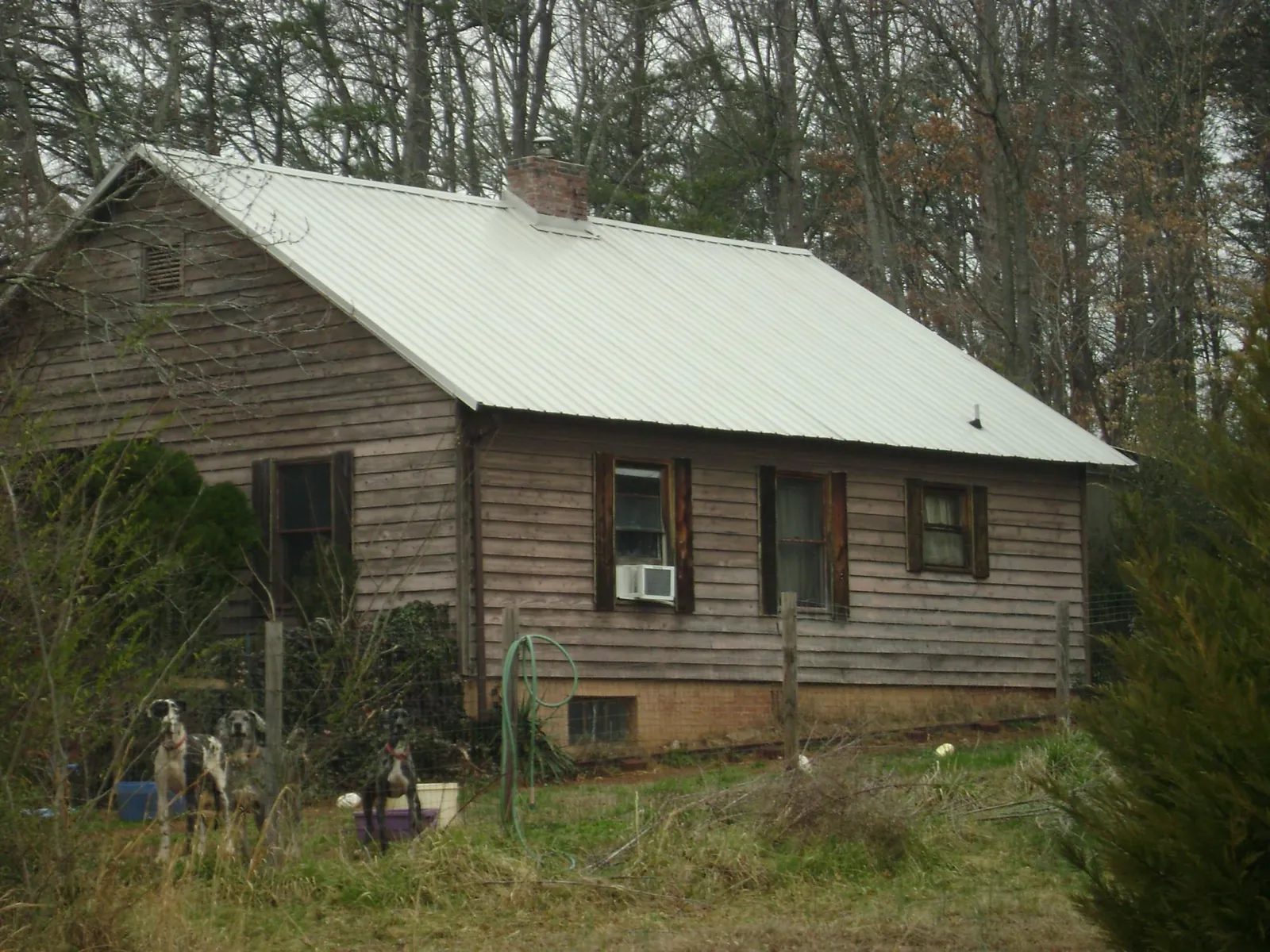 White metal roof on an old wood sided farmhouse, from a Metal Roof Installation job in Magee